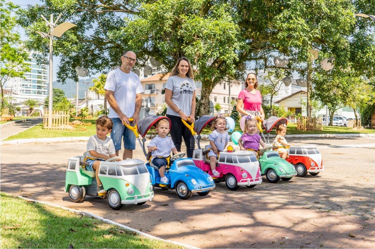 pais e maes com seus filhos em carrinho de passeio
