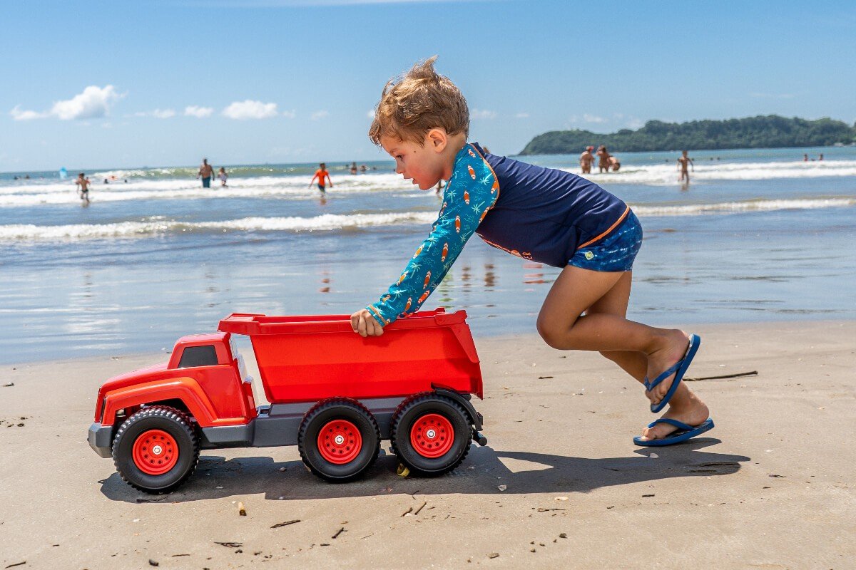 menino empurrando caminhão de brinquedo