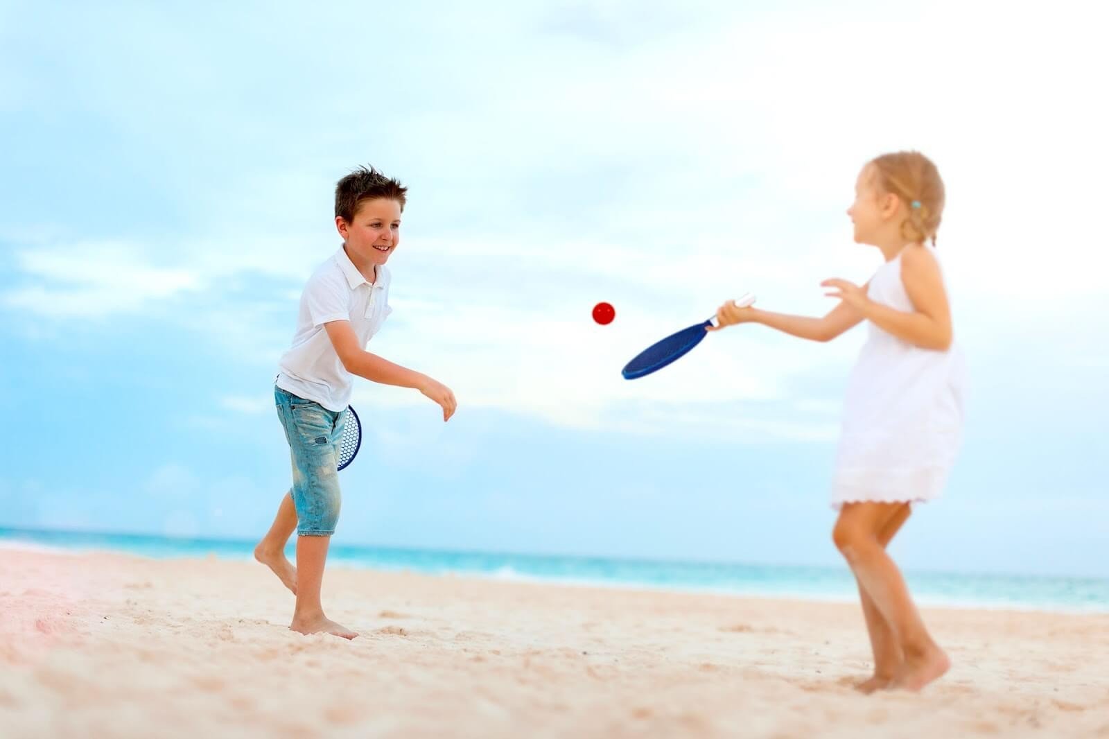 criancas jogando frescobol na praia