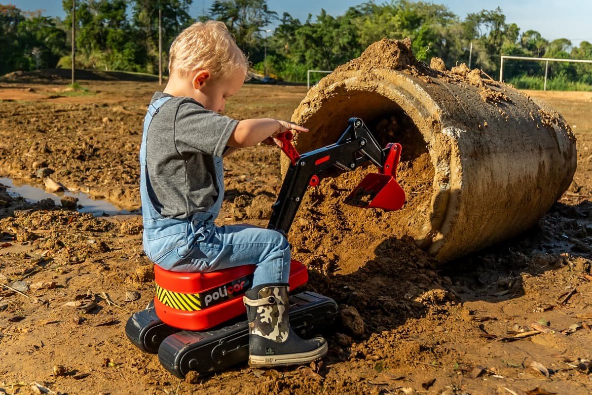 crianca brincando com mini escavadeira de brinquedo