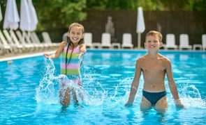 crianças brincando na piscina durante férias escolares
