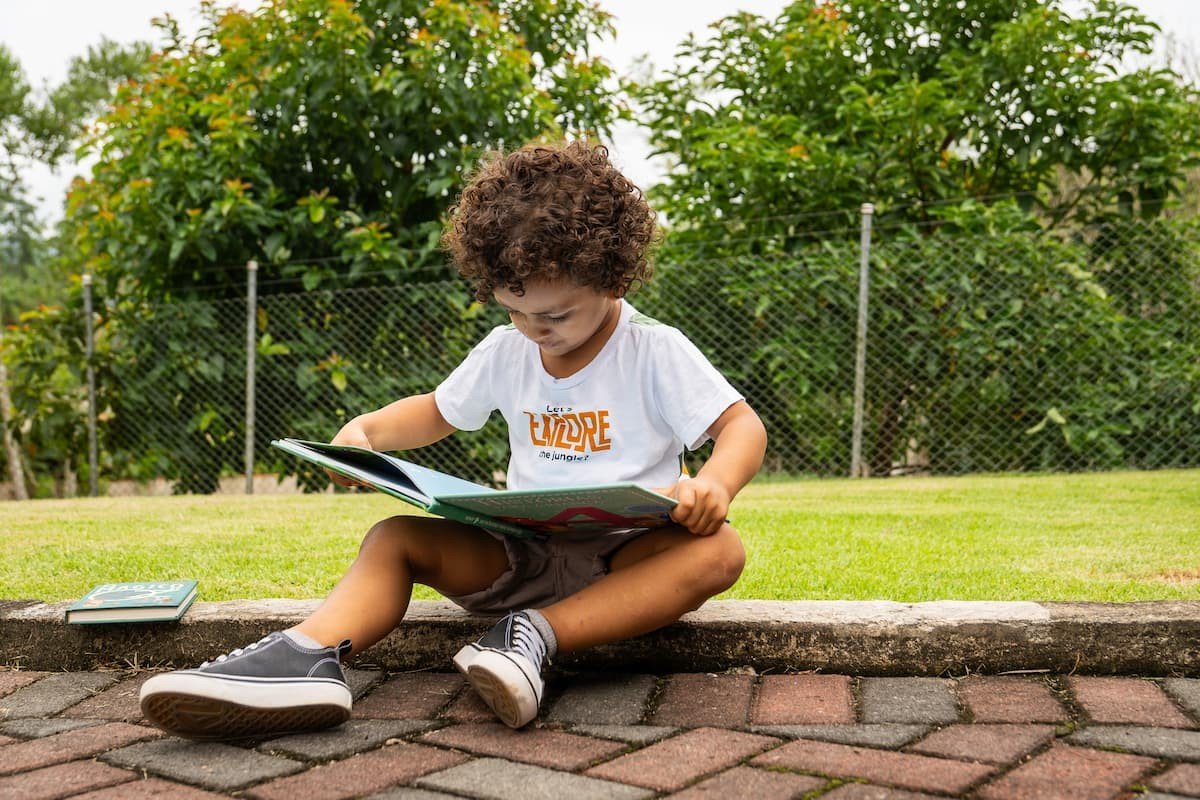 menino sentado lendo um livro